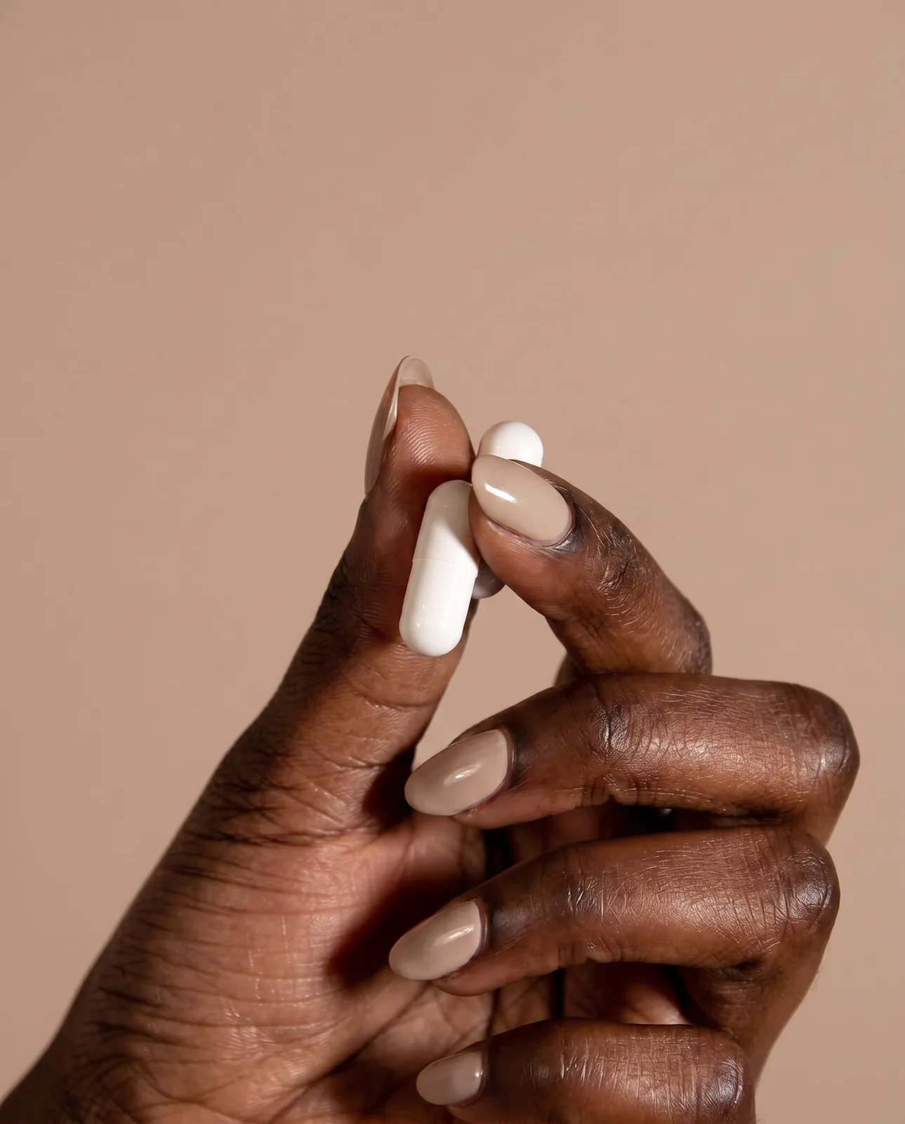Hand holding two Probioderm capsules